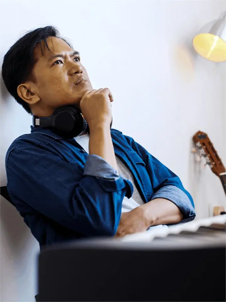 A man wearing headphones with his hand on his chin, unsure what to practise next