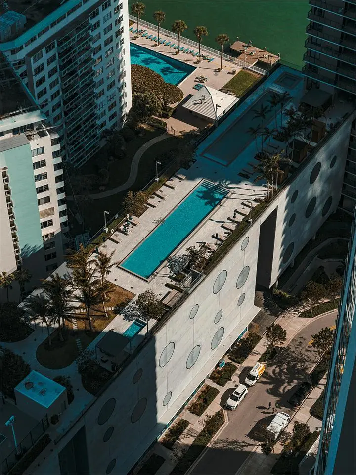A residential tower with a swimming pool and palm trees