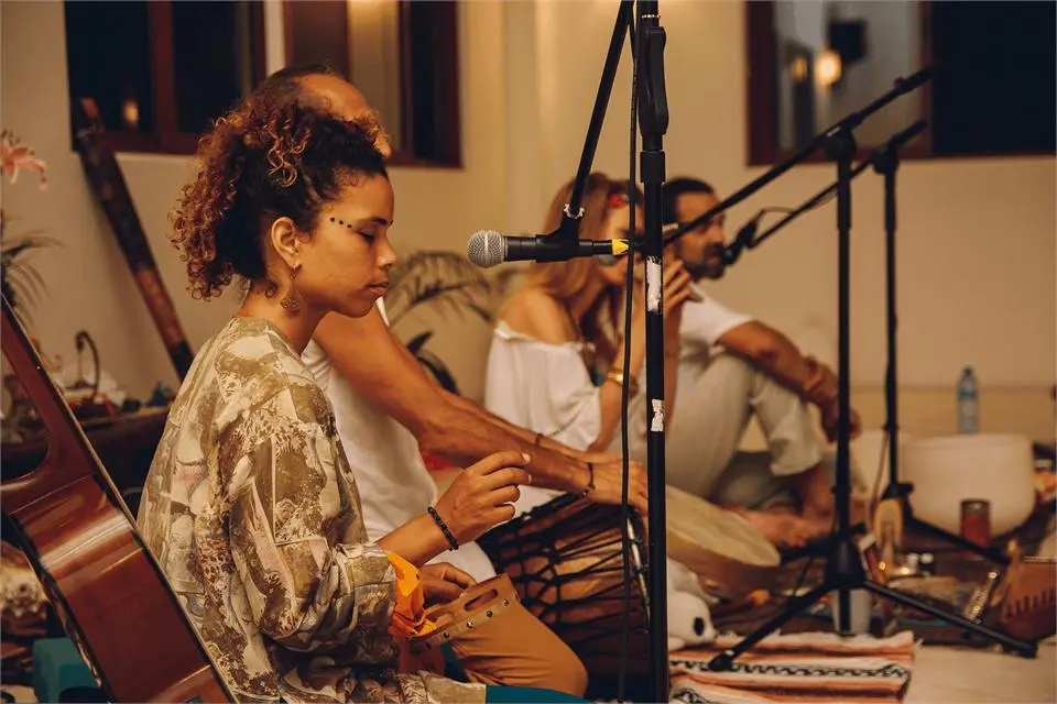 Students playing percussion and singing into microphones in a music class